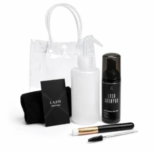 Black Transparent Deluxe Lash Kit in a clear PVC bag containing a lash shampoo bottle, cleansing bottle, soft face cloth, eyelash wand, cleansing brush, and aftercare card. Complete lash extension cleansing and aftercare set for maintaining clean, healthy lashes.