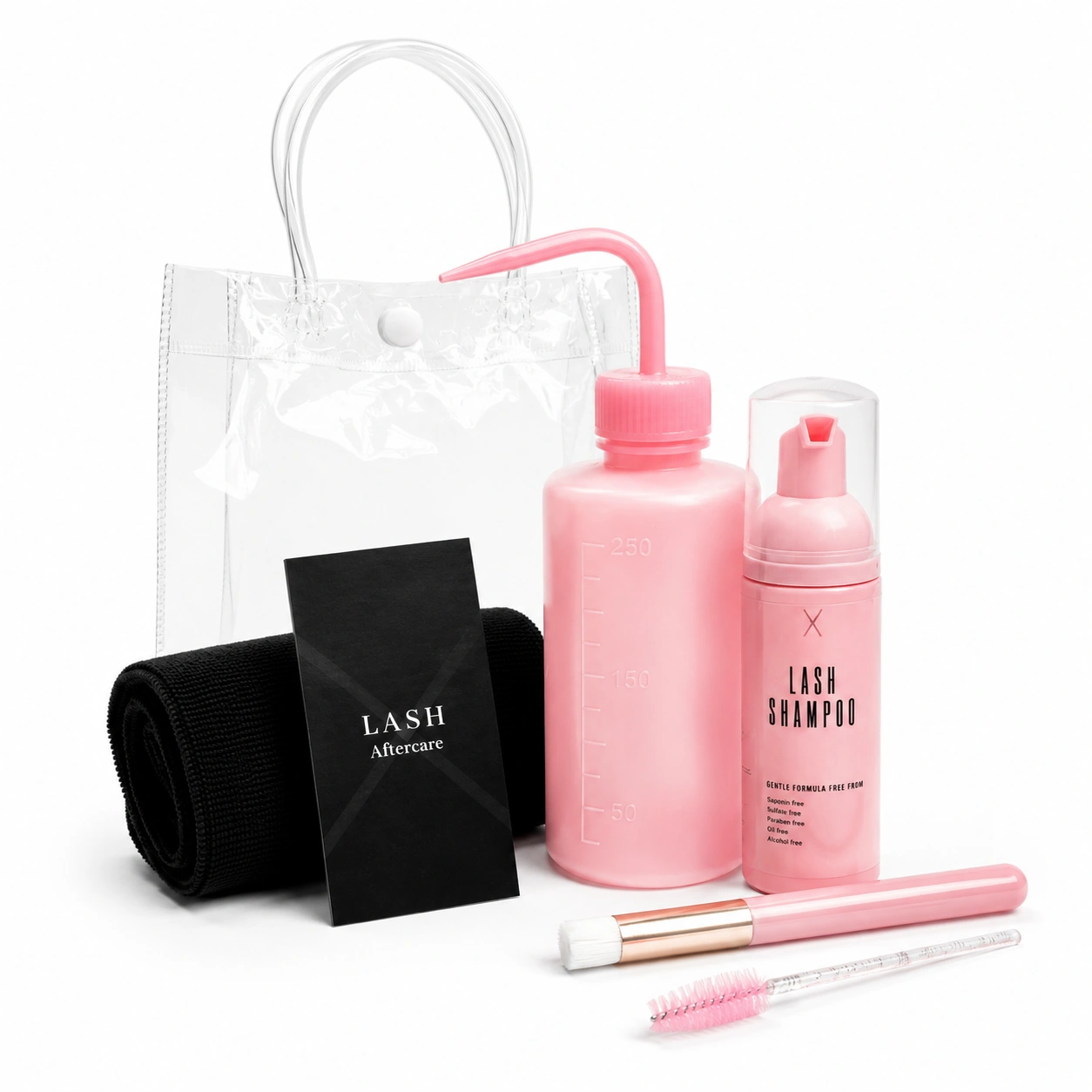 Full Pink Deluxe Lash Kit in a clear PVC bag containing a lash shampoo bottle, cleansing bottle, soft face cloth, eyelash wand, cleansing brush, and aftercare card. Complete lash extension cleansing and aftercare set for maintaining clean, healthy lashes.